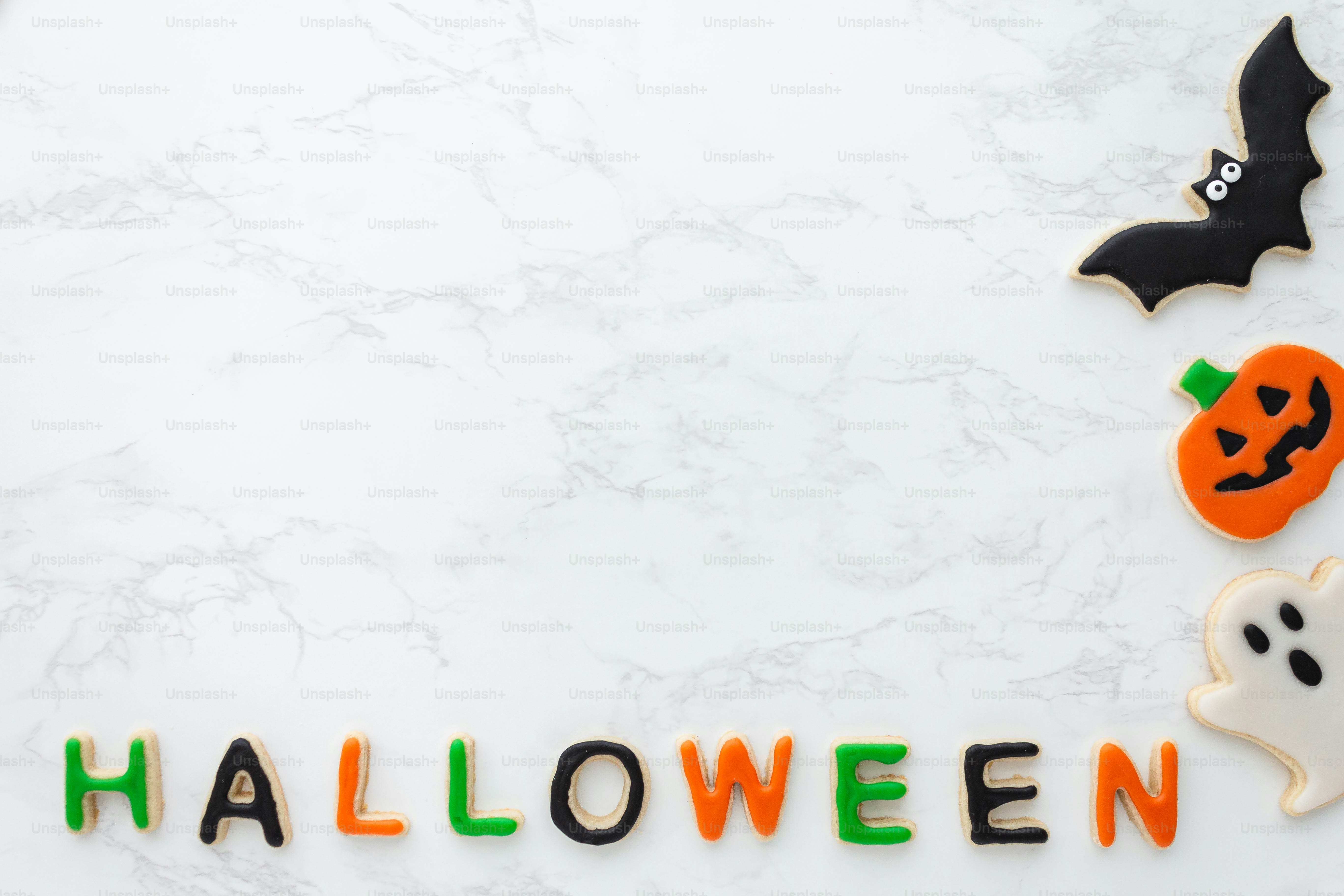 a white marble table topped with halloween cookies