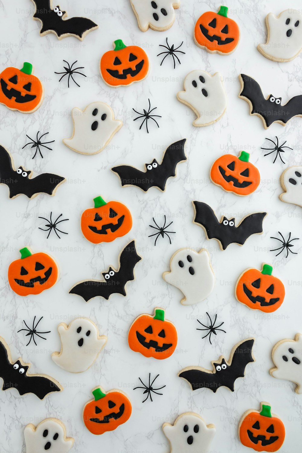 a table topped with lots of decorated halloween cookies