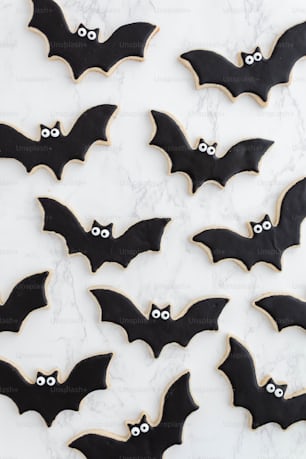 decorated cookies with black icing and decorated bats