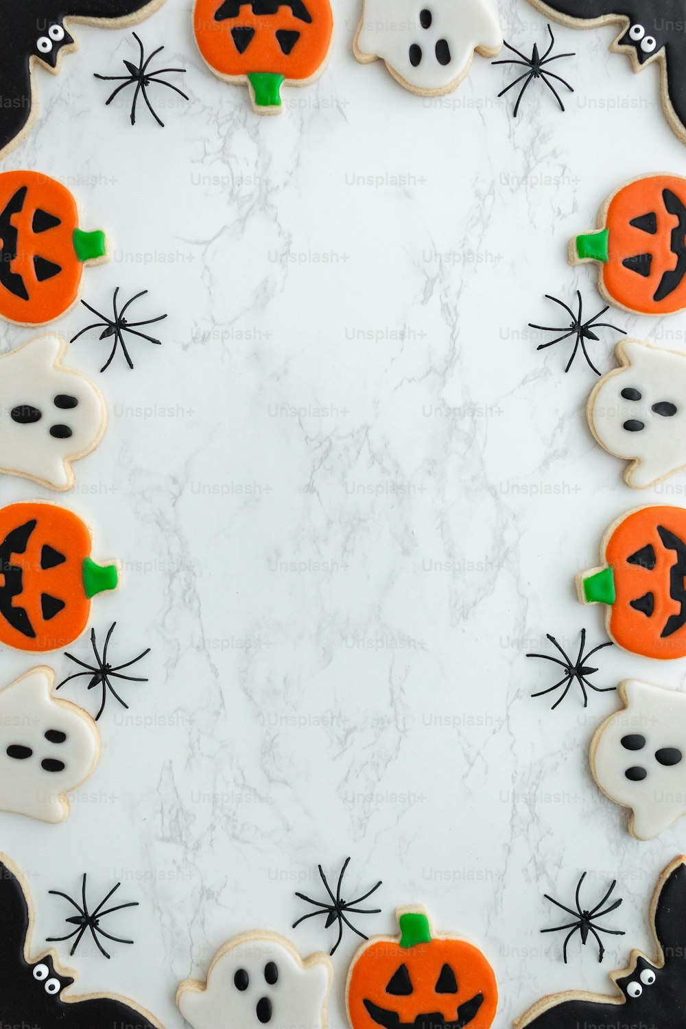 decorated cookies arranged in the shape of ghost and pumpkins