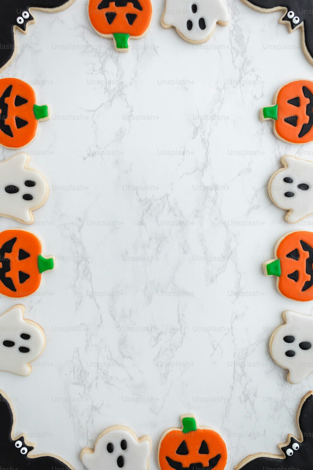 decorated cookies arranged in the shape of ghost and pumpkins