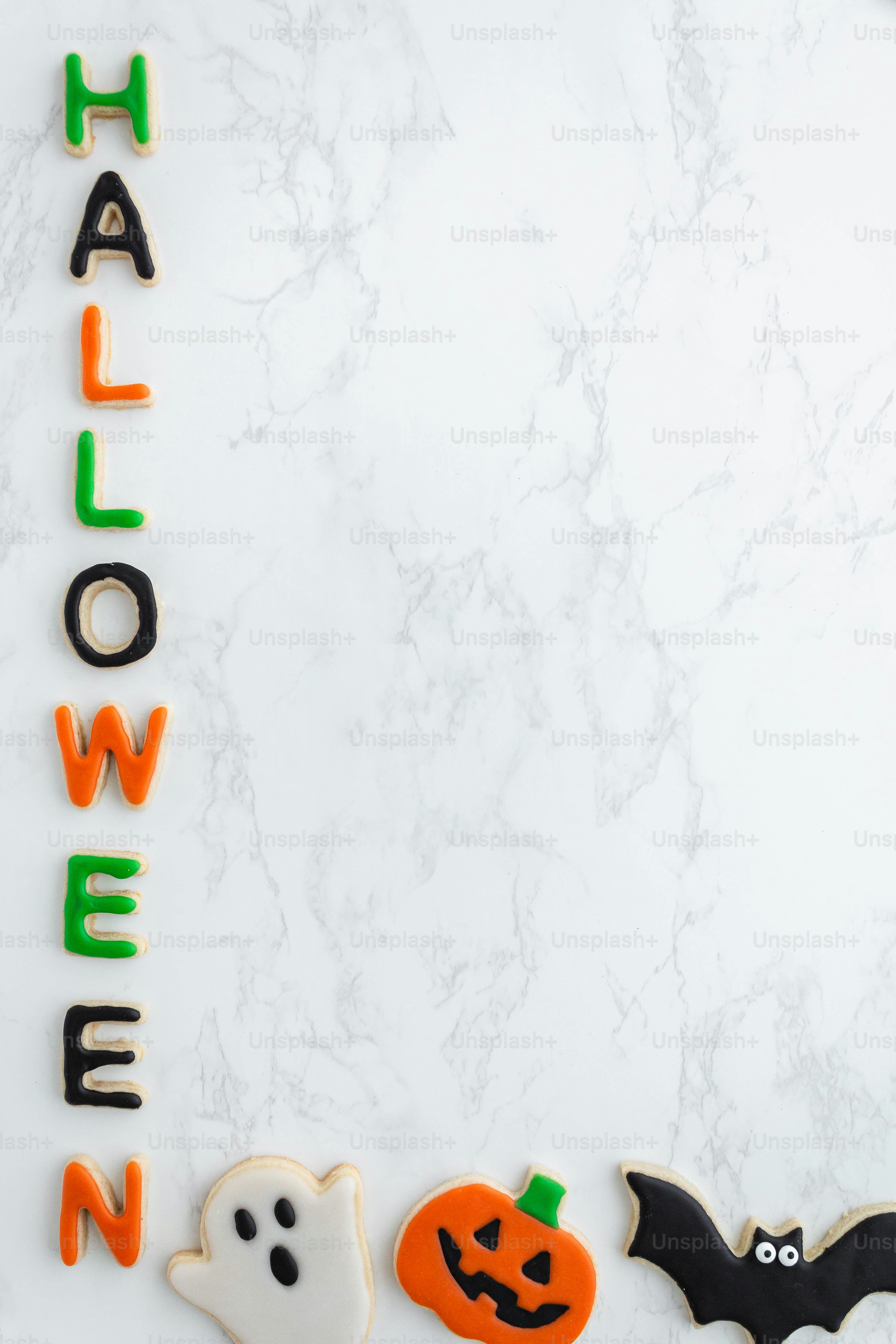 a white marble table topped with halloween cookies