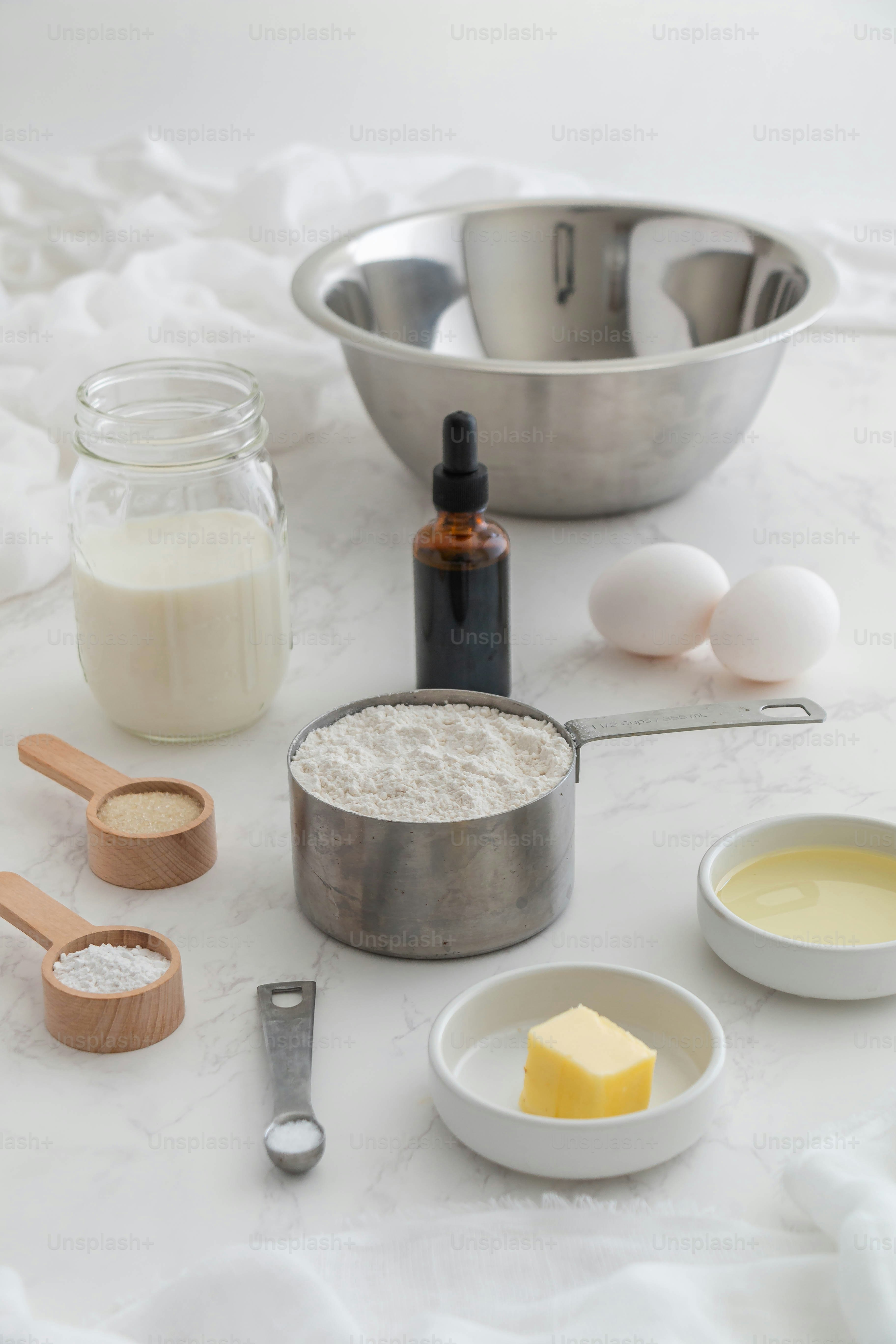 a table topped with bowls of ingredients and a measuring cup