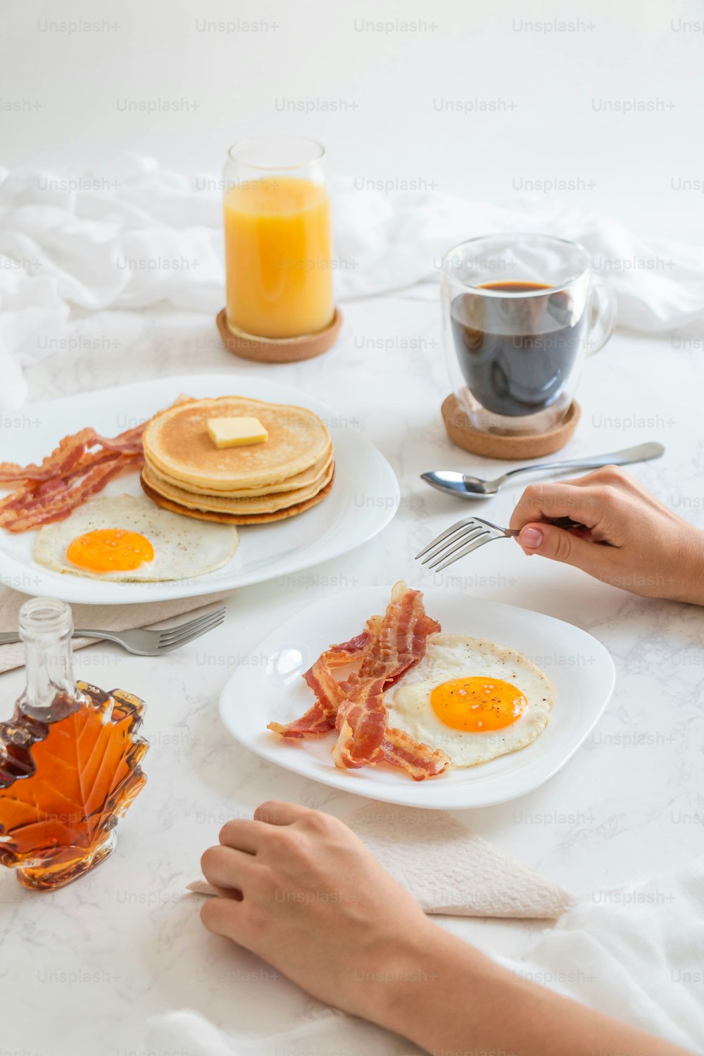 a person sitting at a table with breakfast food