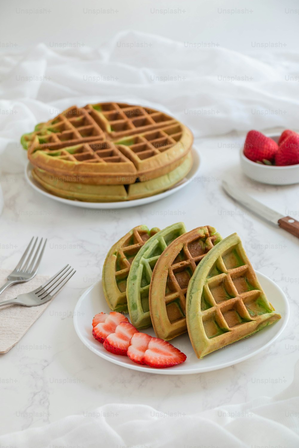 a plate of waffles and strawberries on a table