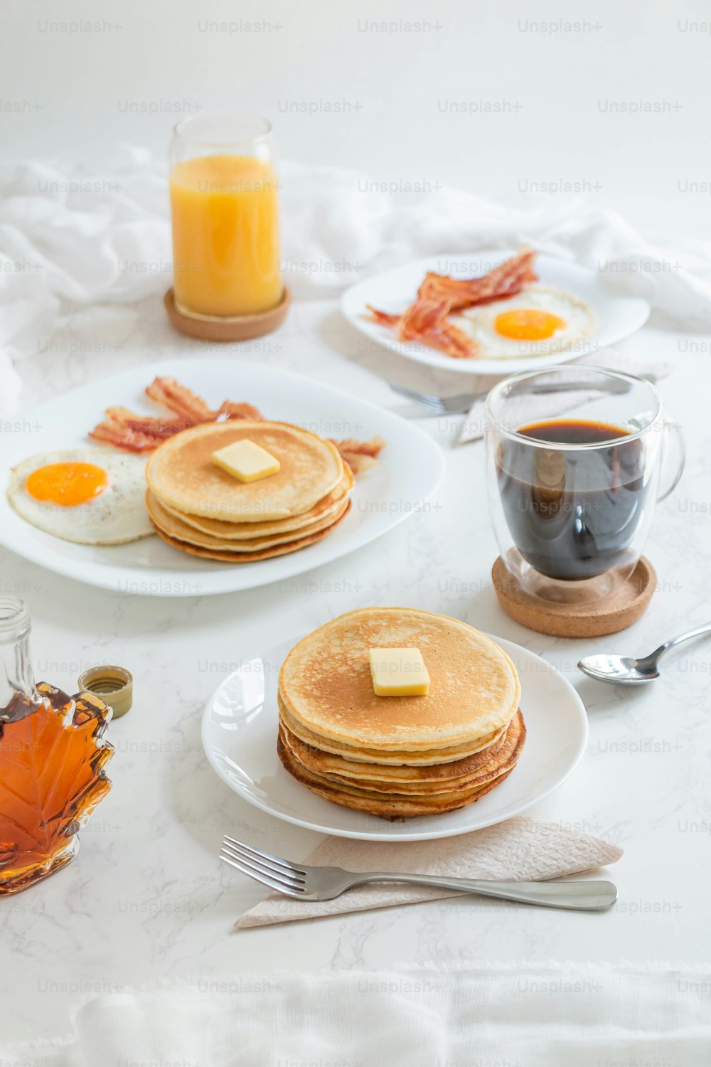 a white table topped with pancakes and eggs