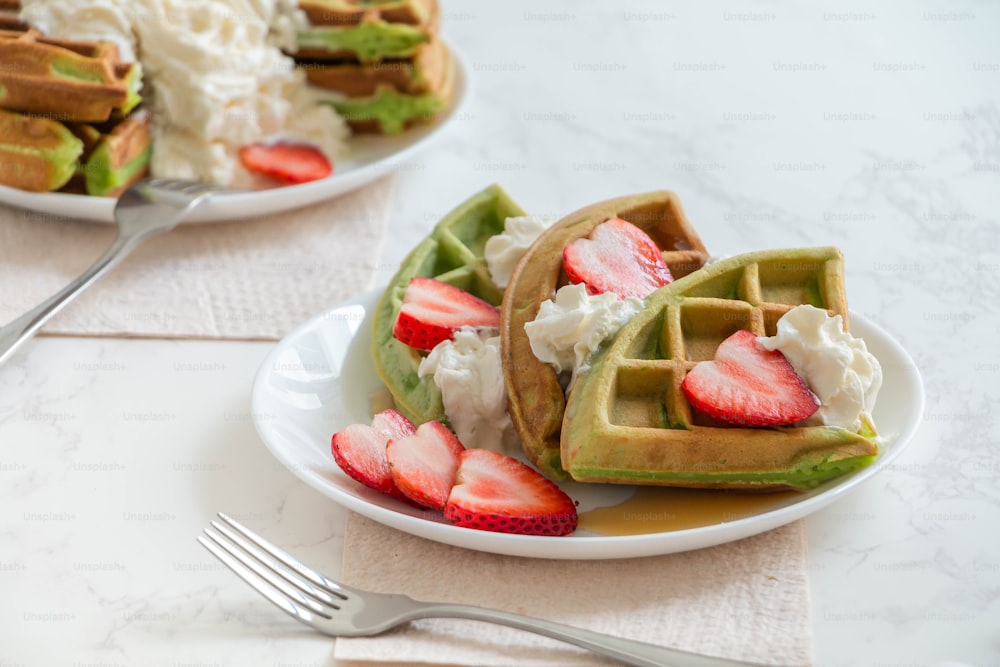 a white plate topped with waffles covered in fruit