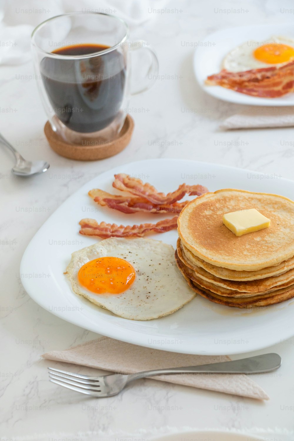 un piatto bianco condito con pancake e uova