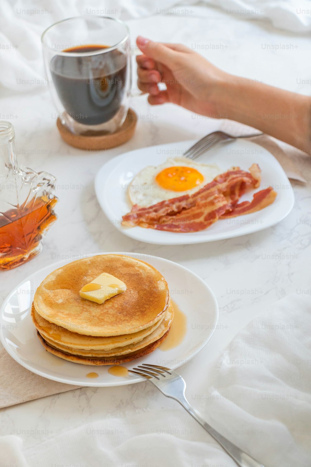 a breakfast of pancakes, bacon, and a cup of tea