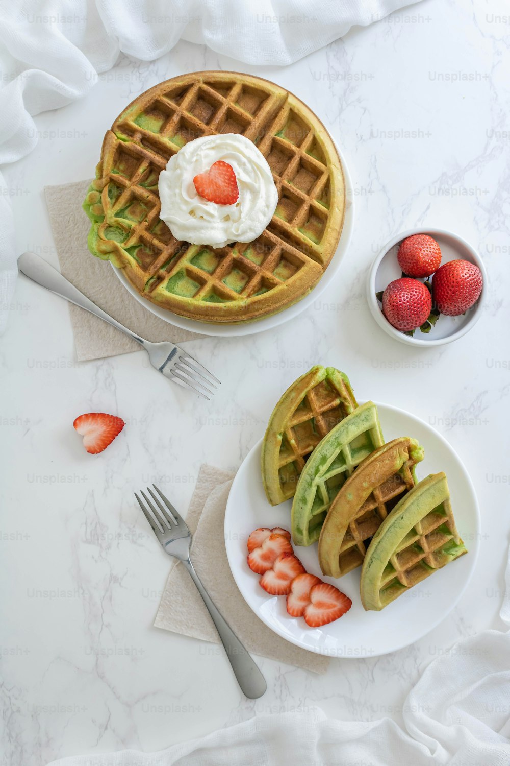 waffles with strawberries and whipped cream on a plate
