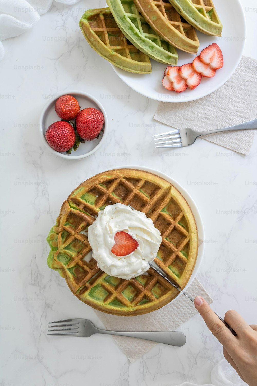 a waffle topped with whipped cream and strawberries