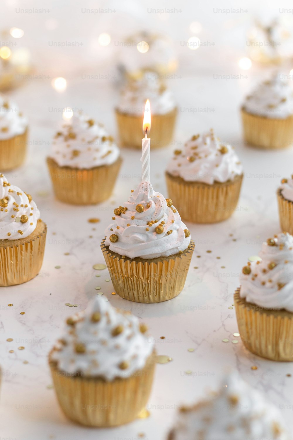 cupcakes with white frosting and a lit candle