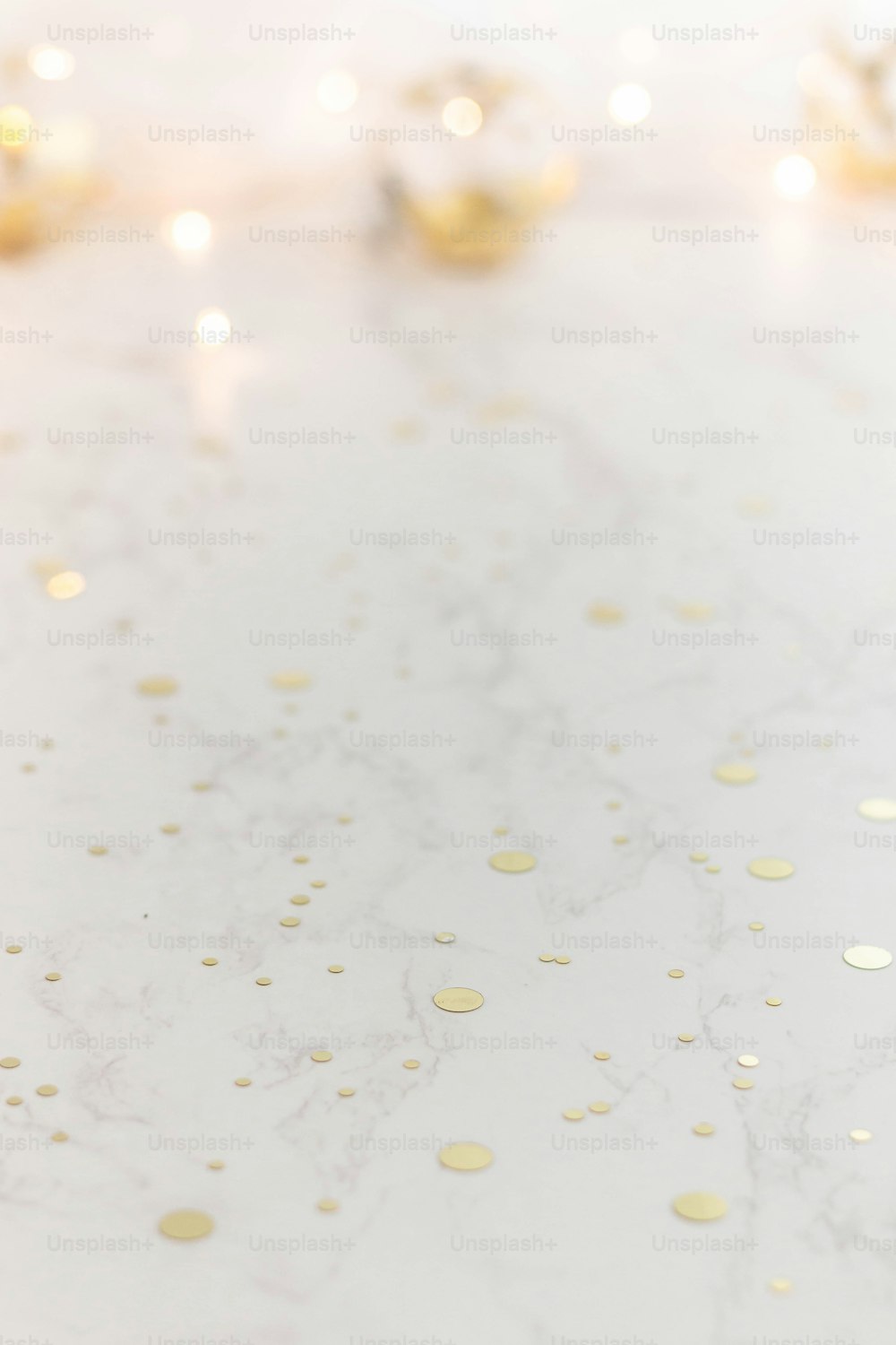 a white table topped with a cake covered in gold confetti