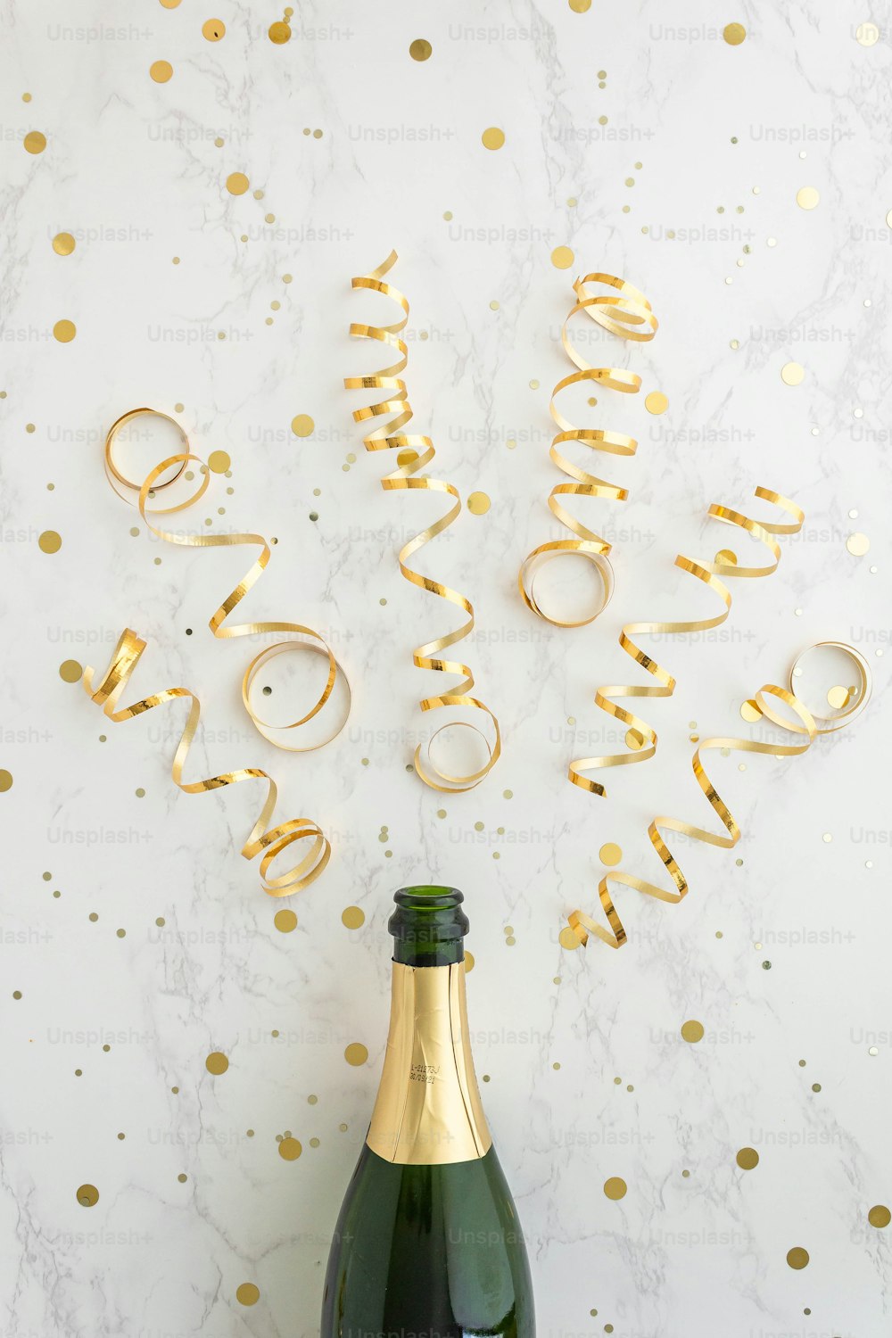 a bottle of champagne sitting next to a gold streamer