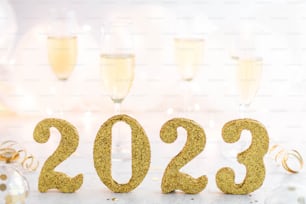 a number made out of gold glitter next to champagne glasses