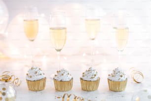a group of cupcakes sitting next to champagne glasses