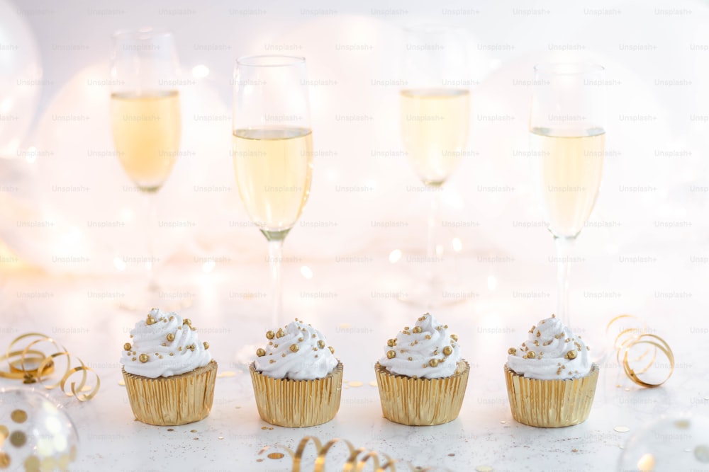 a group of cupcakes sitting next to champagne glasses