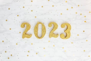 une table blanche surmontée de chiffres dorés et de confettis
