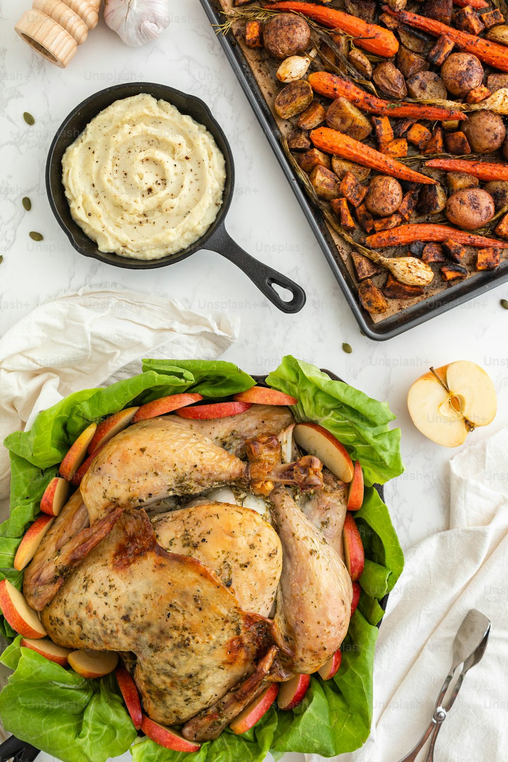 a roasted chicken and vegetables on a bed of lettuce