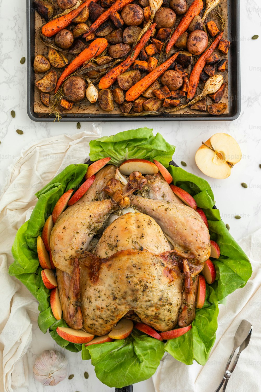 a roasted chicken and carrots on a bed of lettuce
