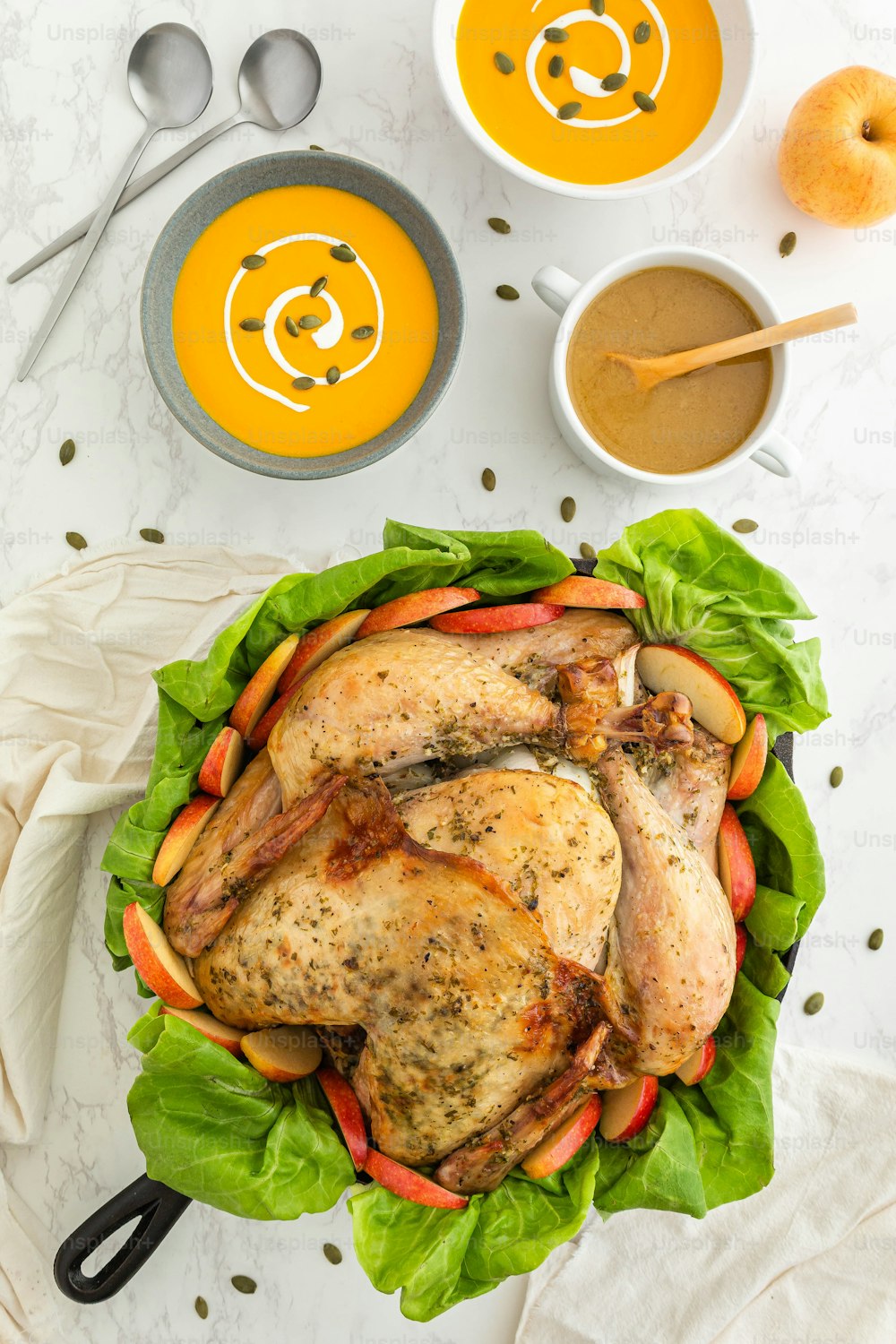 a roasted chicken in lettuce with carrots and apples