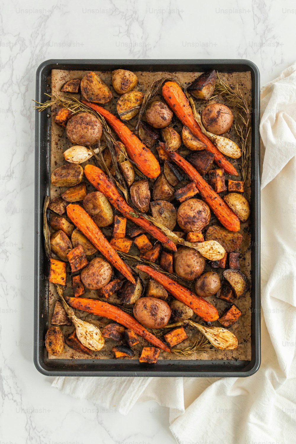 a tray of roasted carrots and potatoes