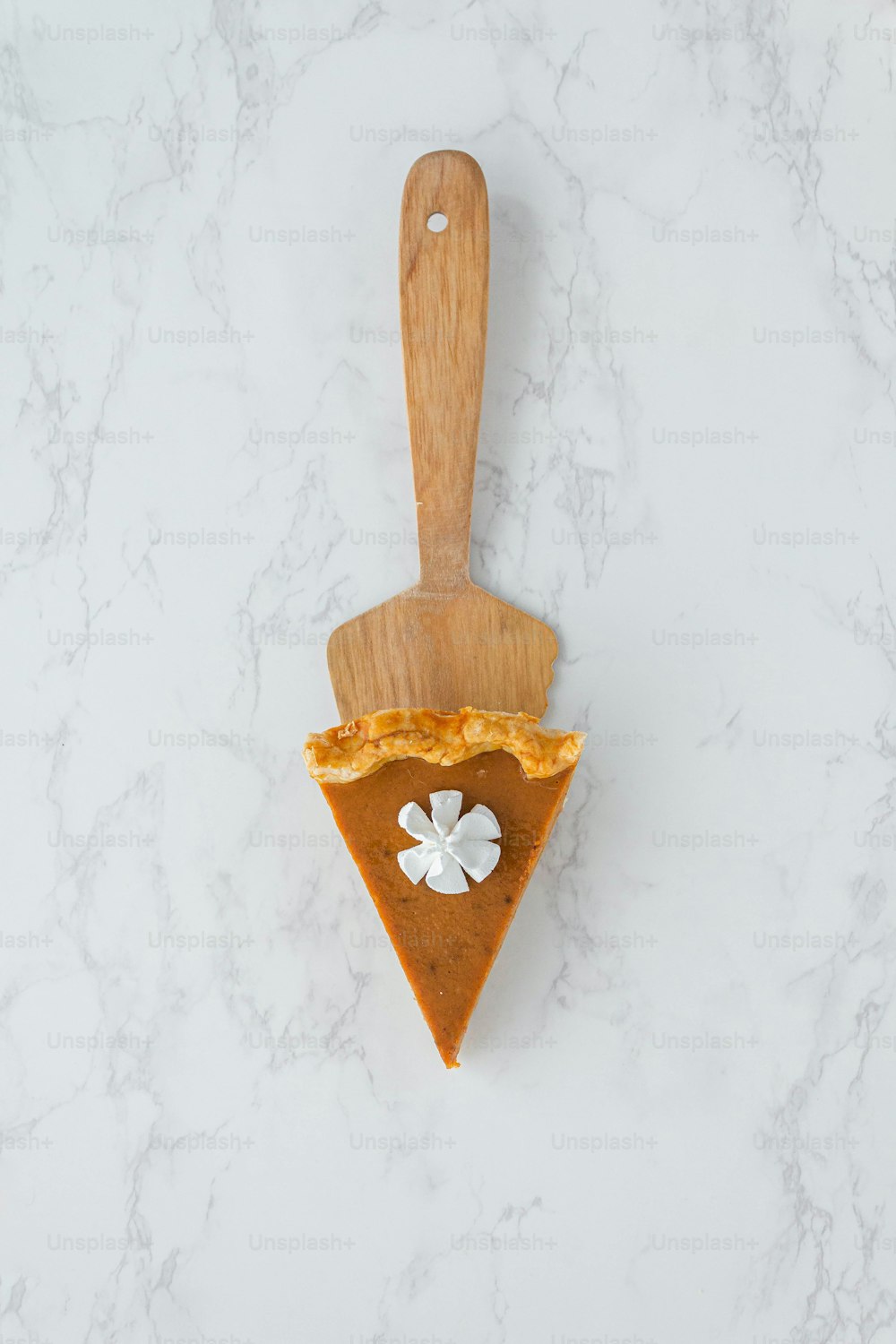 a piece of pie on a wooden spatula