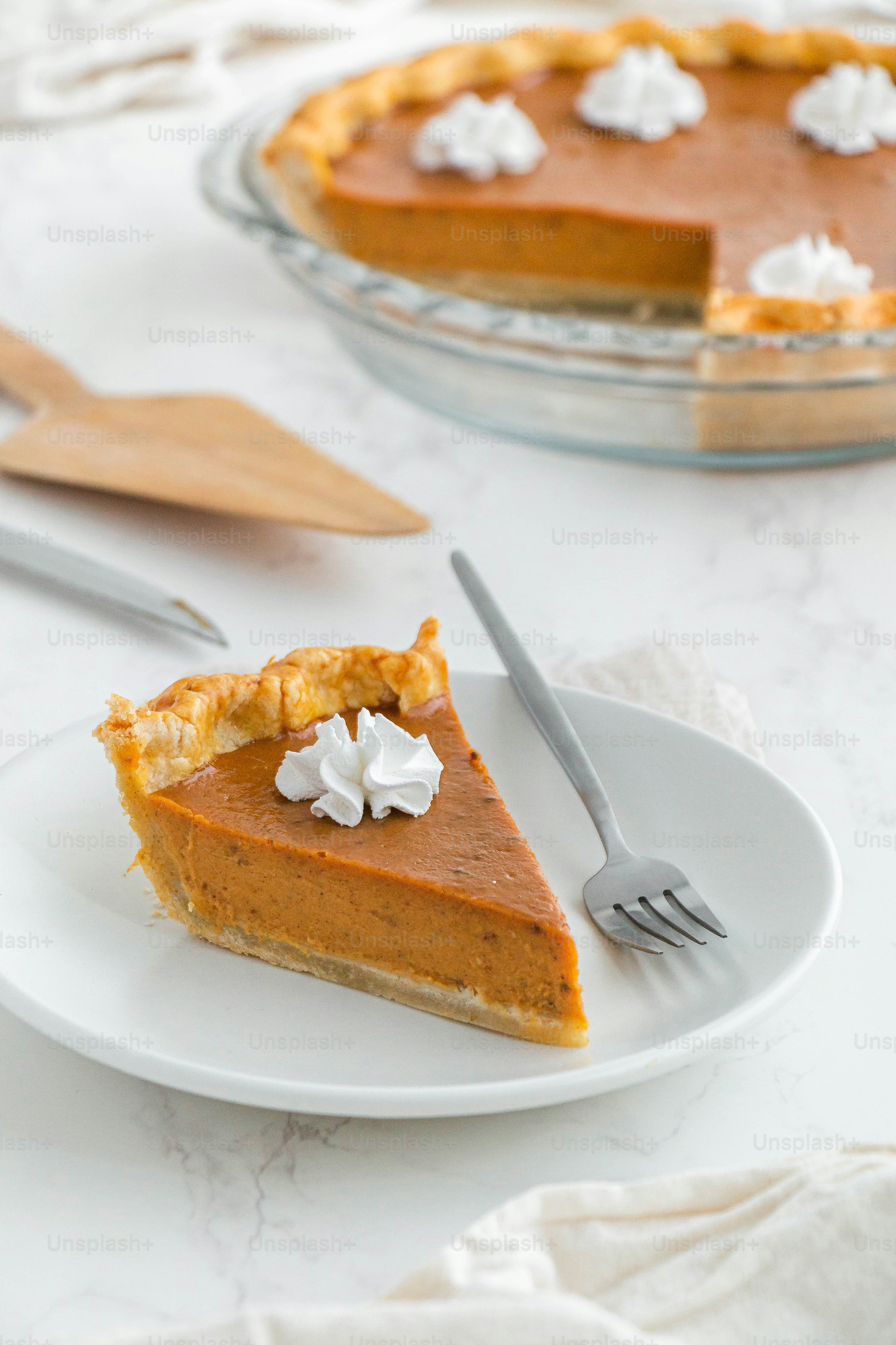 a slice of pumpkin pie on a plate with a fork