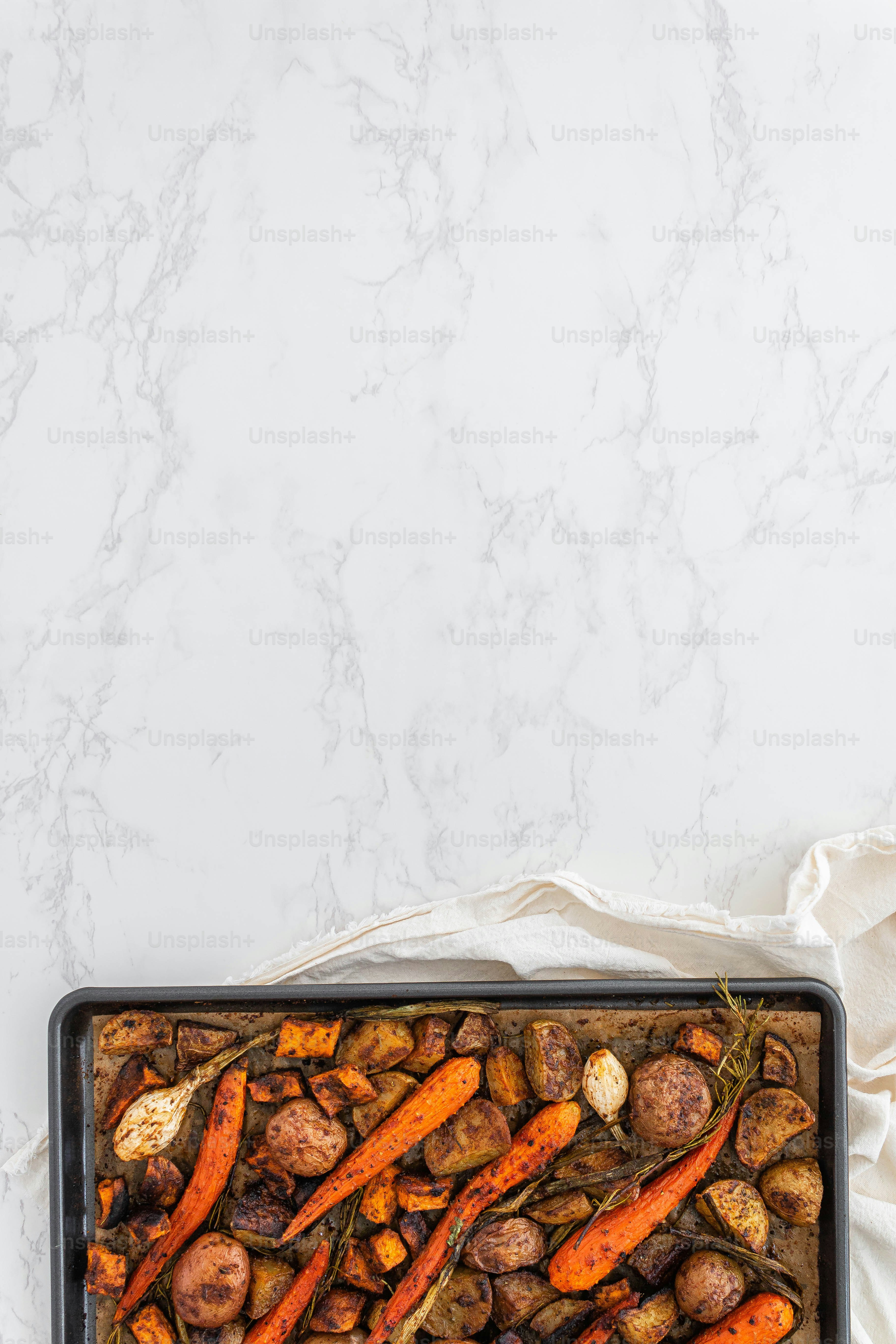 a pan filled with carrots and potatoes on a table