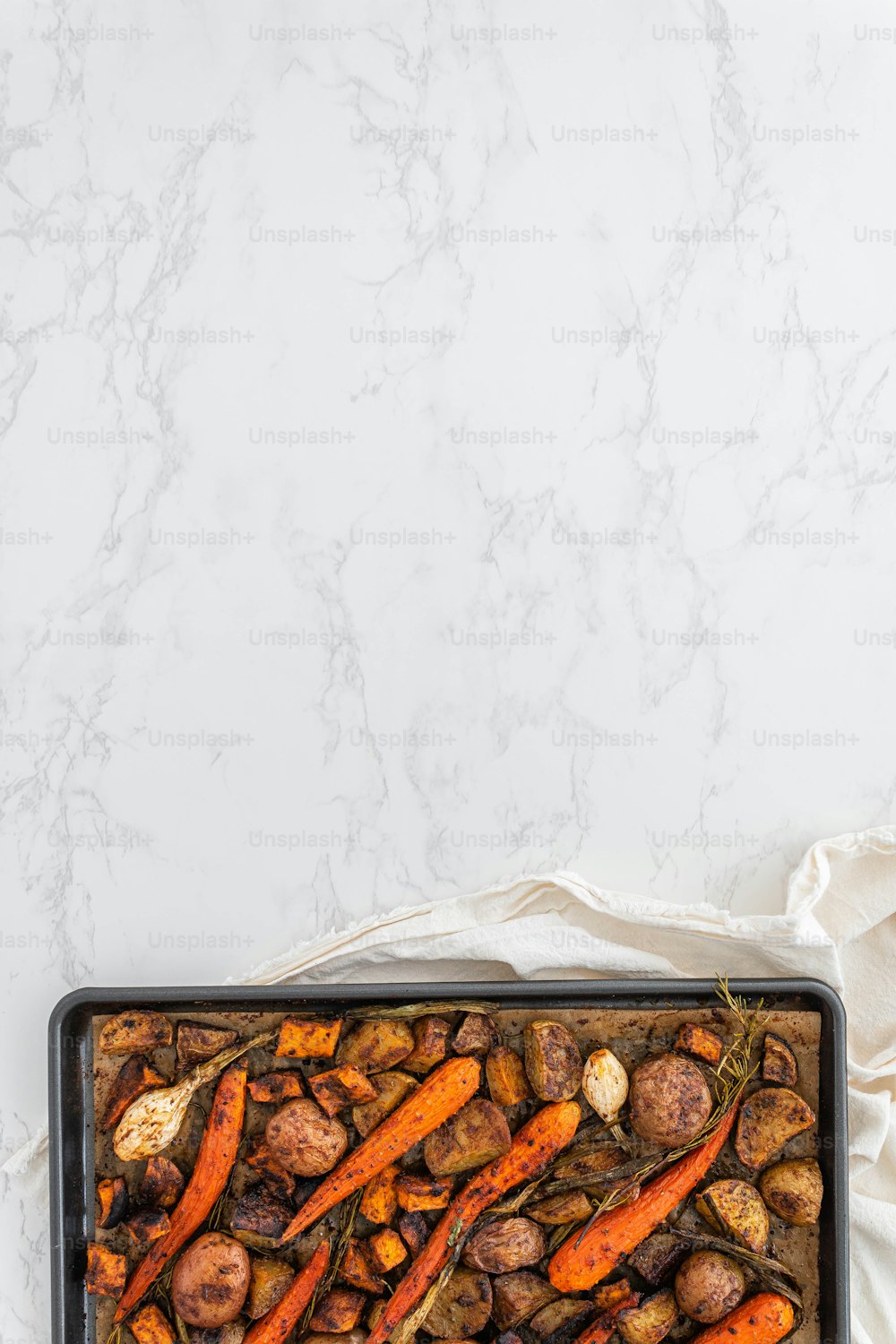 a pan filled with carrots and potatoes on a table