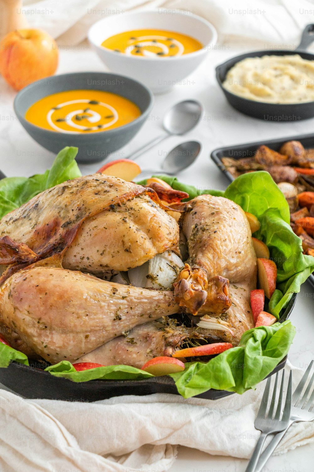 a roasted turkey in a pan with a side of sides