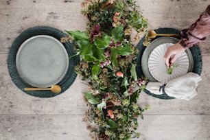 una mesa cubierta con platos y flores encima de una mesa de madera
