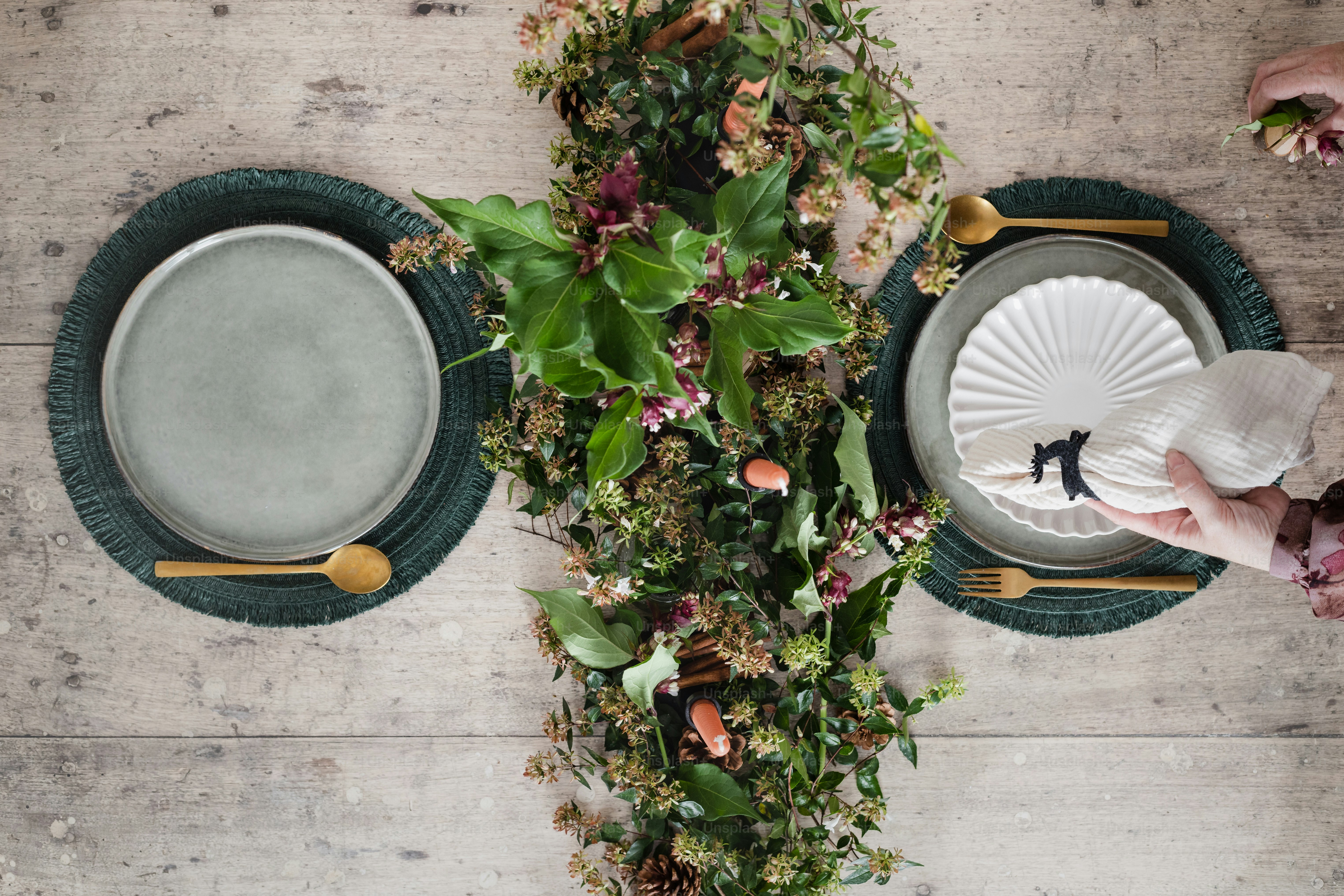 a table topped with plates and a vase filled with flowers