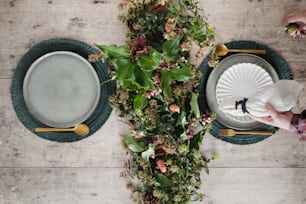 uma mesa coberta com pratos e um vaso cheio de flores