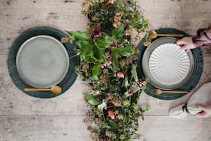 a table topped with plates and flowers on top of a wooden table