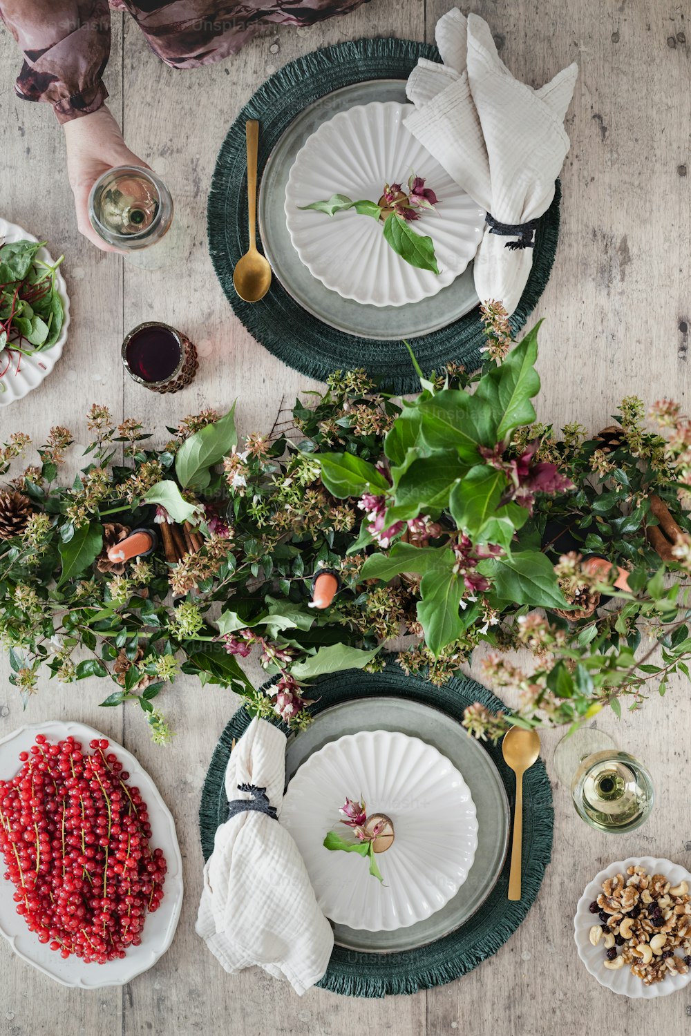 una mesa de madera cubierta con platos y flores