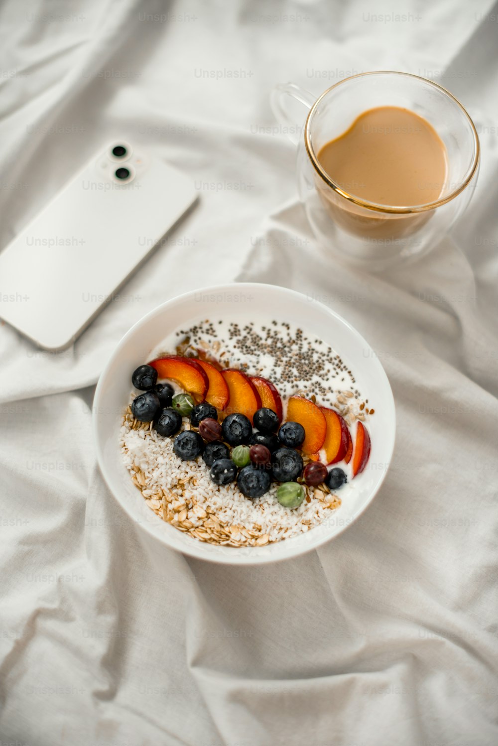 a bowl of oatmeal with fruit and a cup of coffee