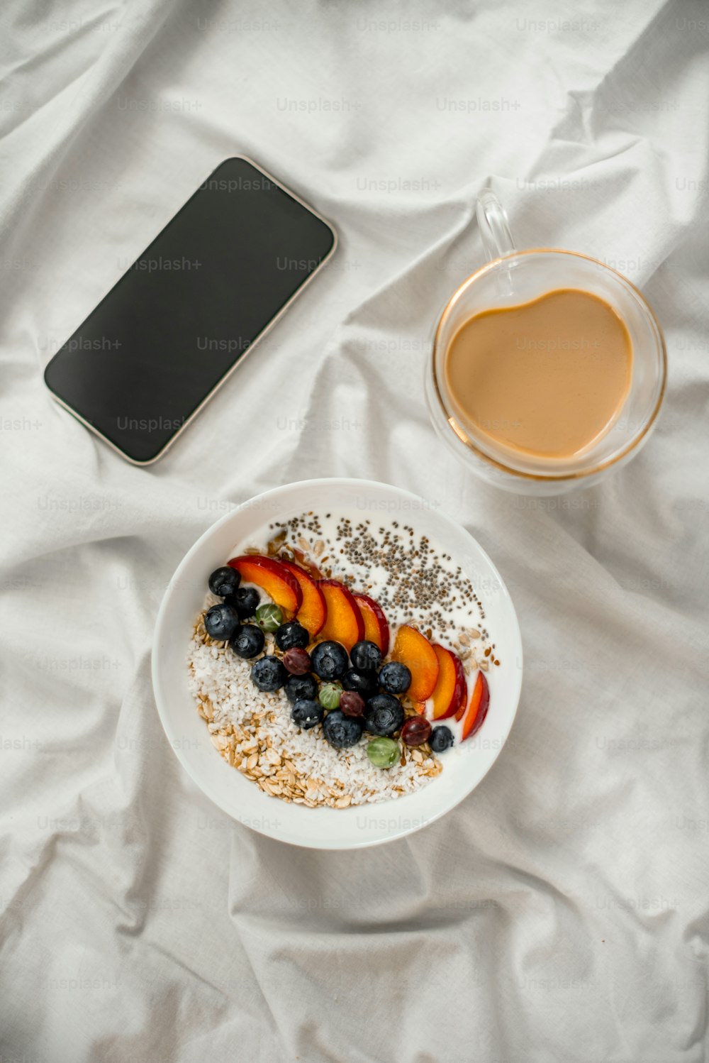 a bowl of oatmeal with fruit and a cup of coffee