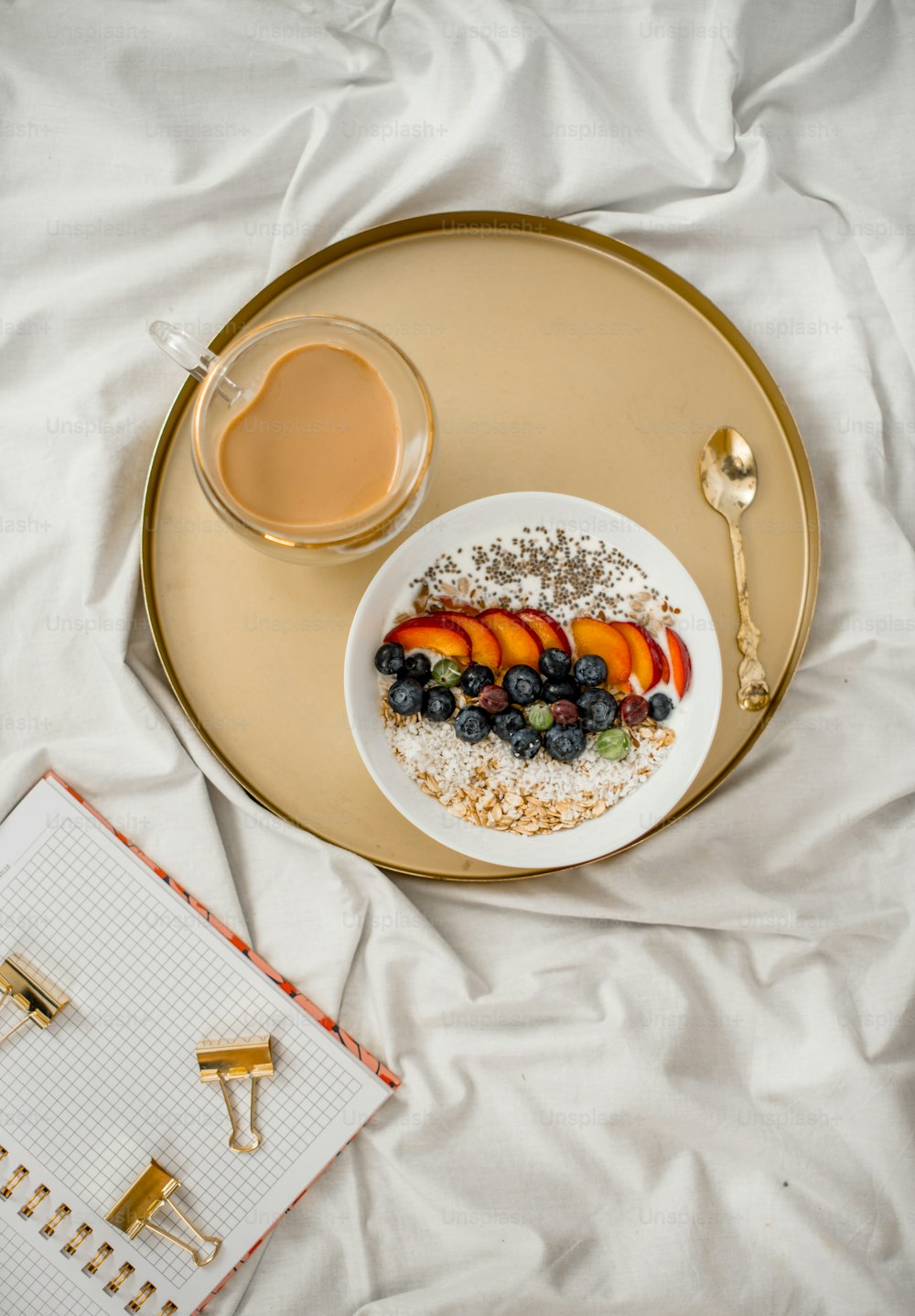 a plate of food and a cup of coffee on a bed