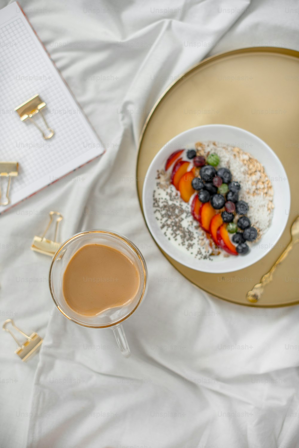 a plate of food and a cup of coffee on a bed