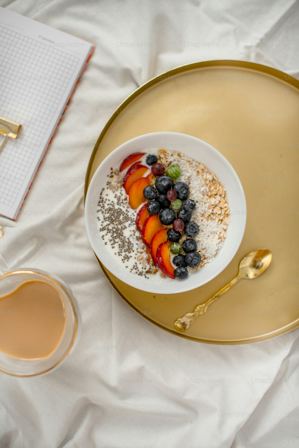 a bowl of oatmeal with fruit and a cup of coffee