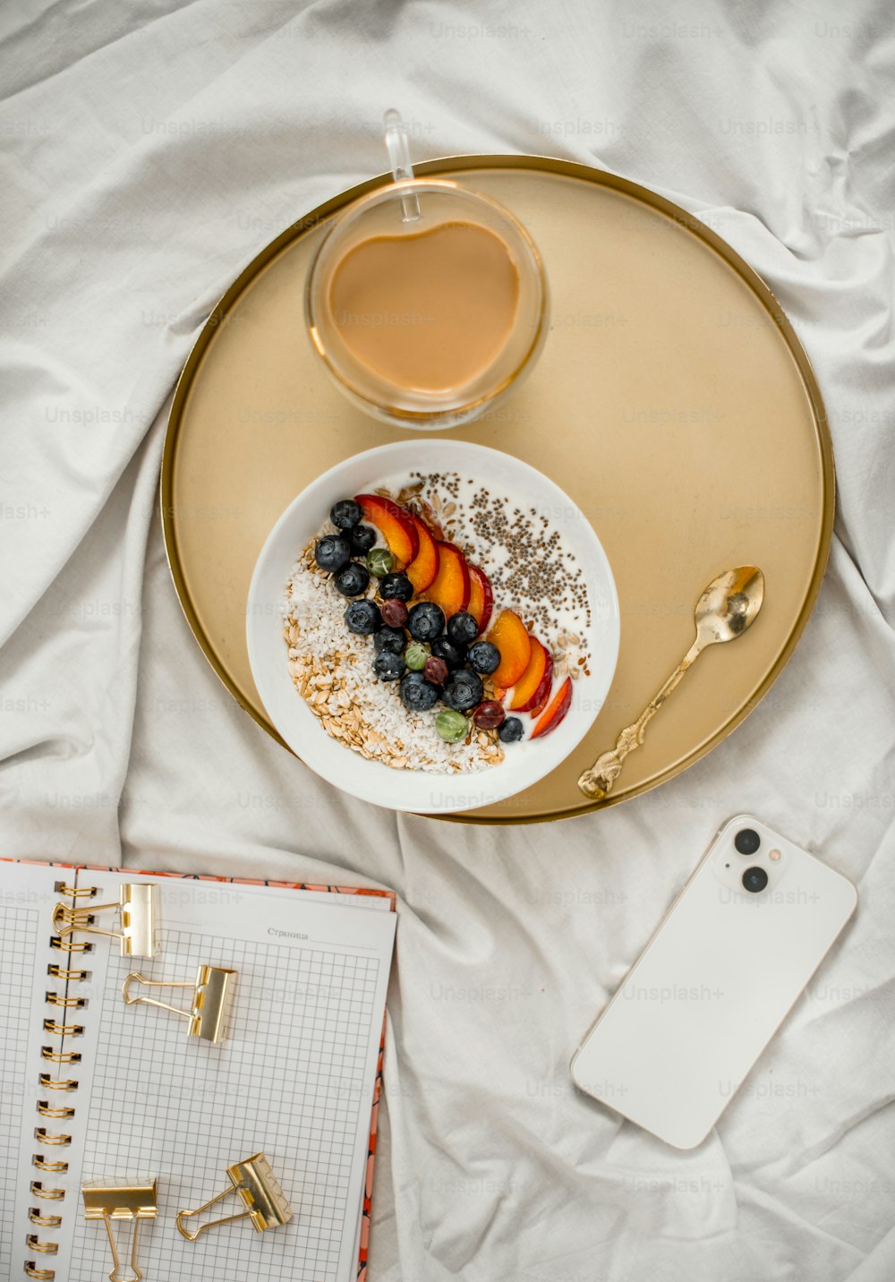 a plate of fruit and a cup of coffee on a bed