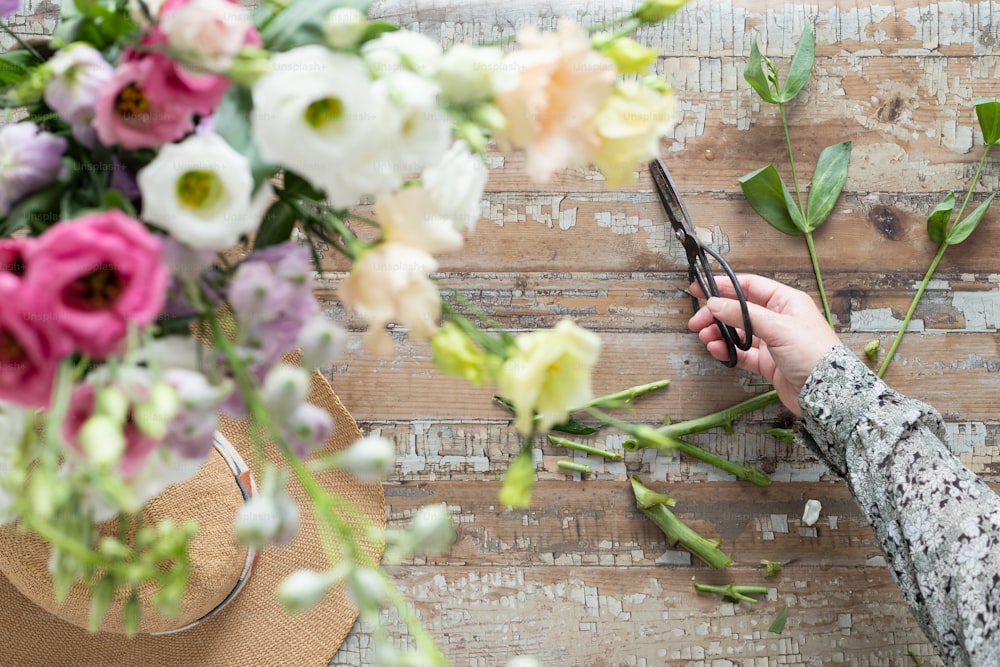 a person cutting flowers with scissors on a table