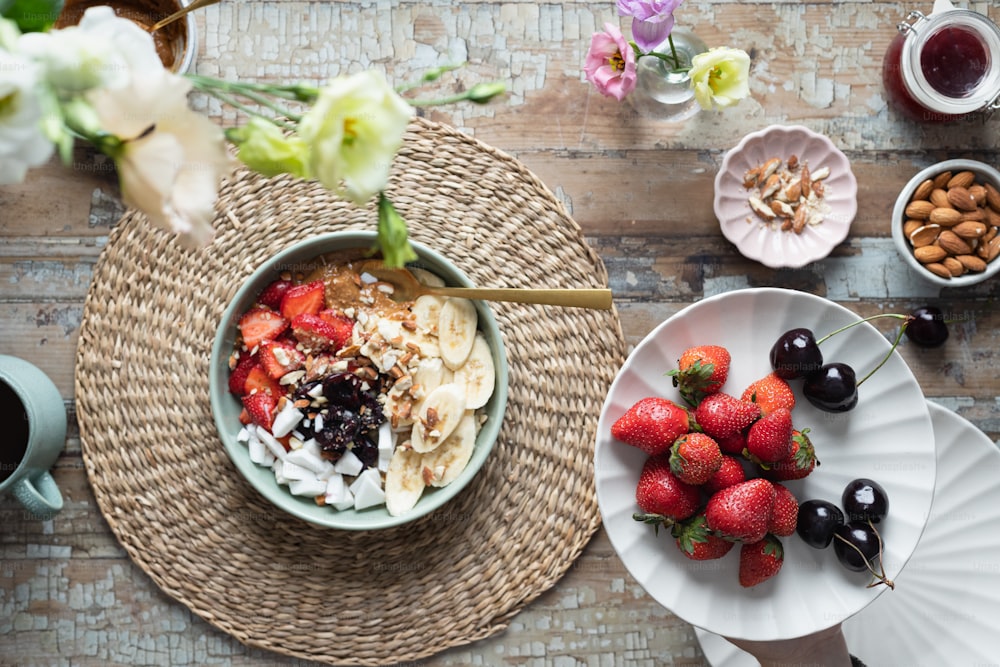 a bowl of yogurt, fruit, and nuts on a table