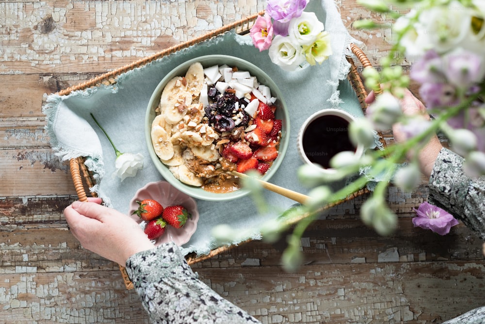 a bowl of cereal with strawberries on a tray