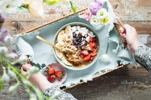 a bowl of fruit and cereal on a tray