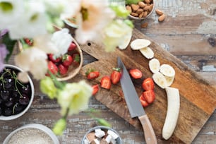 a cutting board topped with sliced bananas and strawberries