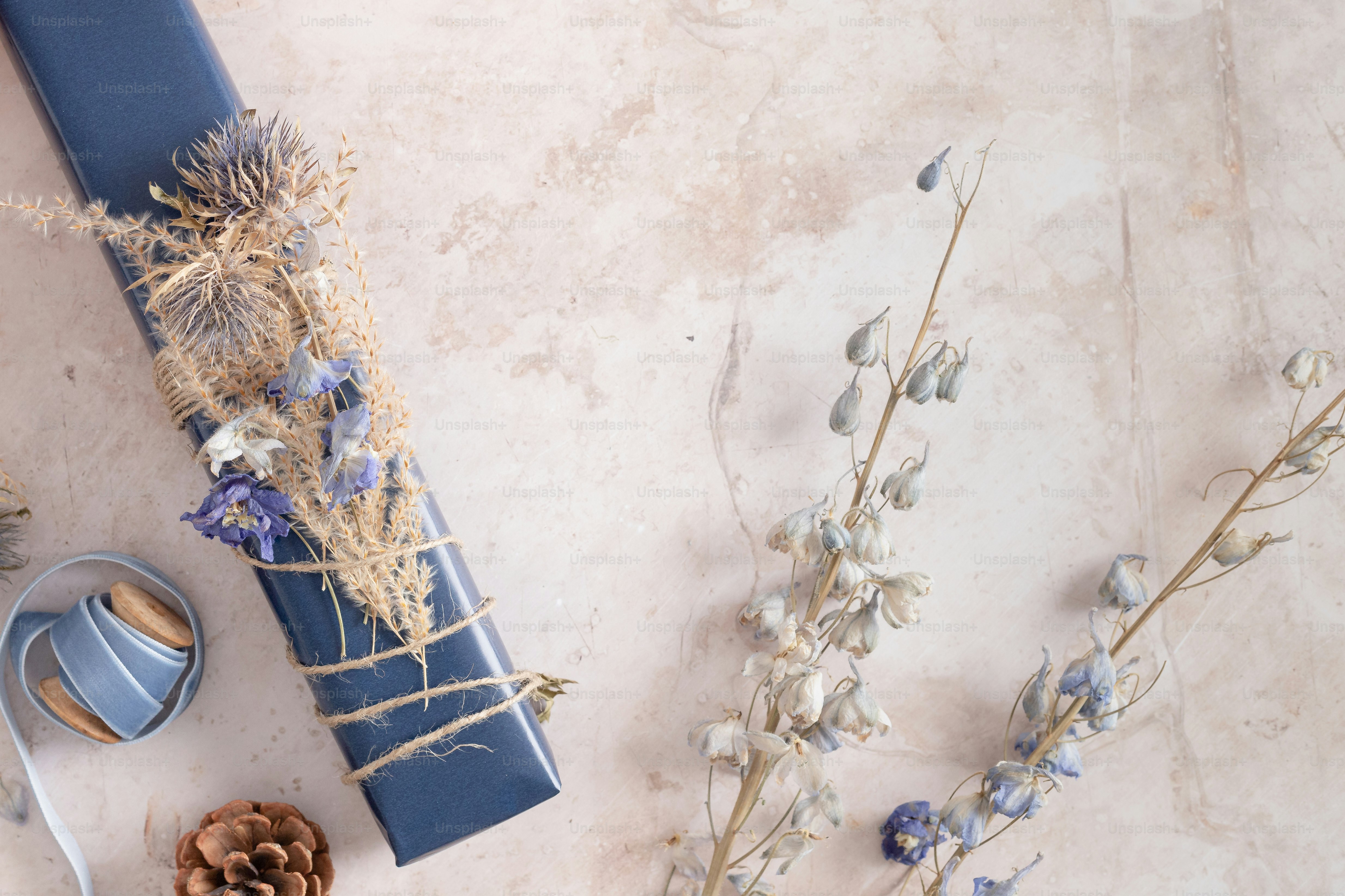 a table topped with a blue vase filled with flowers