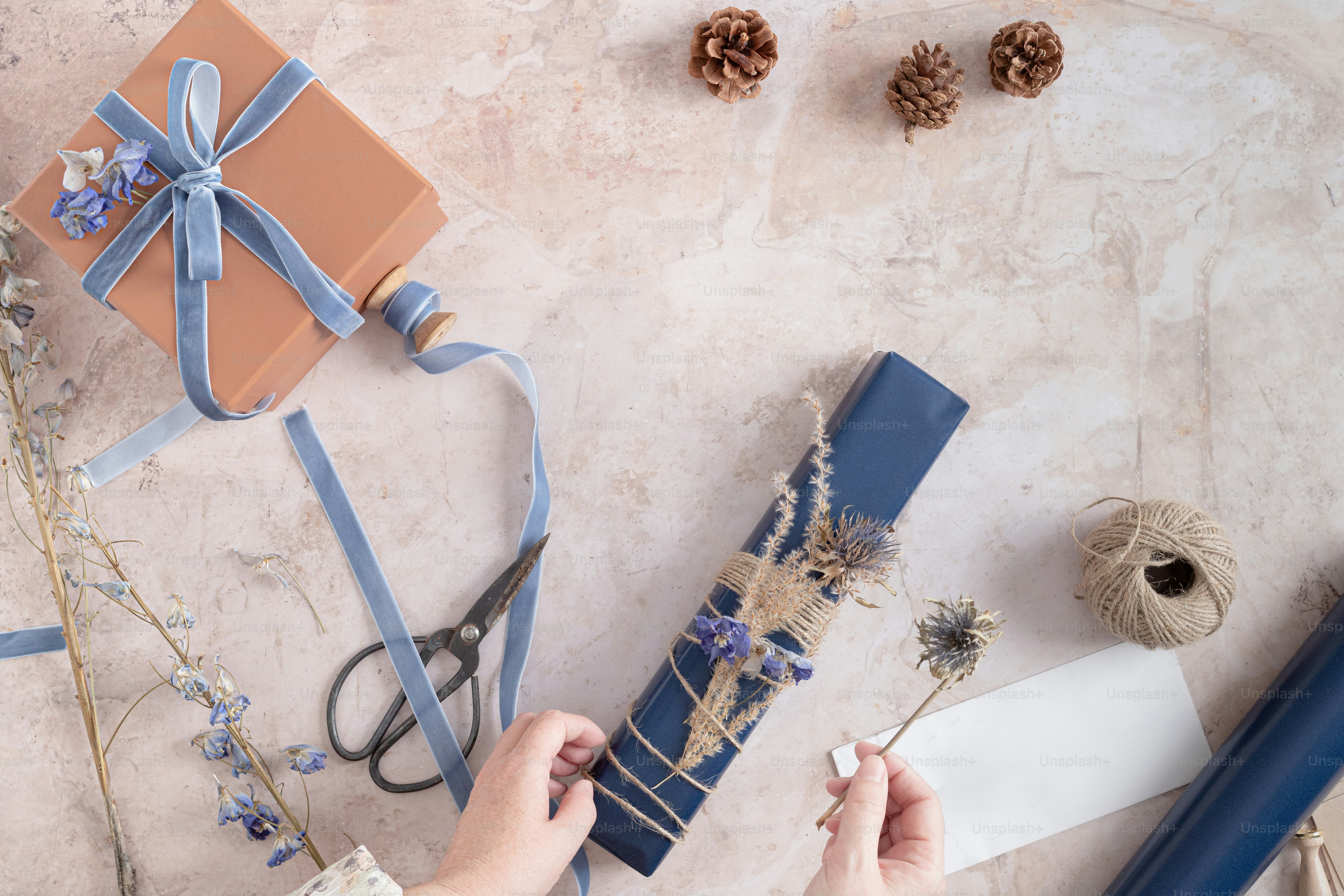 A person is wrapping a gift with a blue ribbon photo Gift Image on