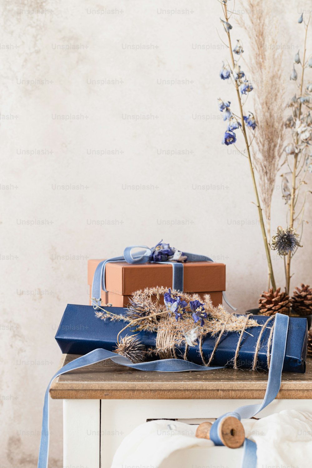 a wooden table topped with blue wrapped presents